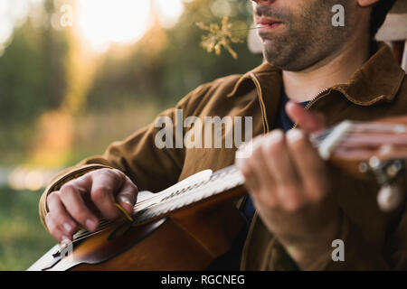 Close-up of young man, plaing the ukulele Stock Photo