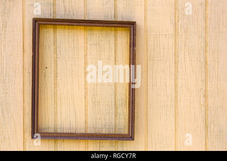 Empty wood picture frame hanging on a wall for decoration. Stock Photo