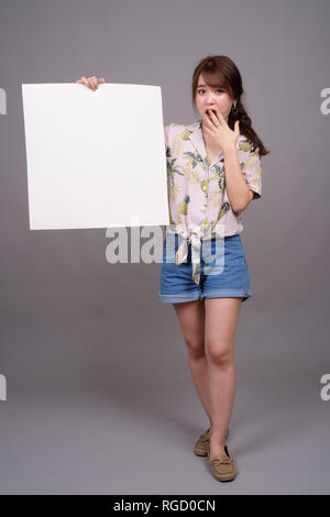 Asian woman holding empty white board with copyspace Stock Photo