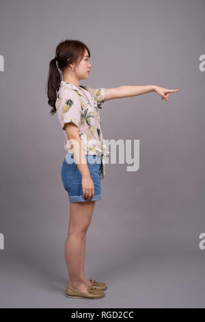 Full length portrait of beautiful young Asian woman standing Stock Photo