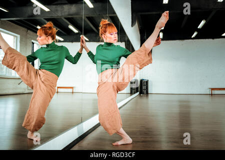 Beautiful professional modern dancer with red hair practicing choreography Stock Photo