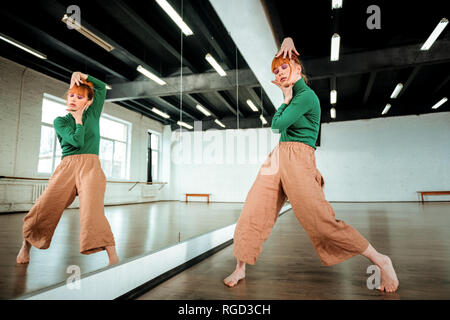 Beautiful professional modern dancer with red hair looking expressive Stock Photo