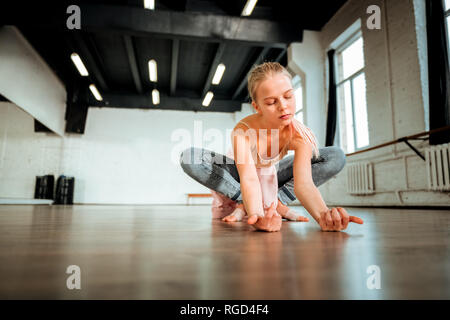 Beautiful blond teenager from generation z sitting in the lotus pose Stock Photo
