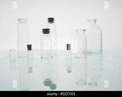 Few transparent bottles, water sprays. empty glass bottles Stock Photo