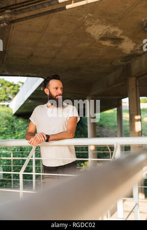 Bearded young man outdoors looking sideways Stock Photo