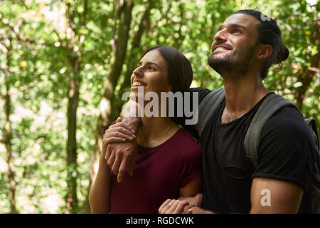 Spain, Canary Islands, La Palma, happy couple standing in a forest looking up Stock Photo
