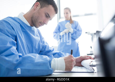 Scientist taking notes in laboratory Stock Photo