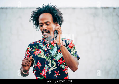 Portrait of man on the phone wearing shirt with floral design Stock Photo