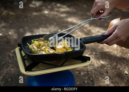 Woman frying vegetable skewer on gas cooker, close-up Stock Photo