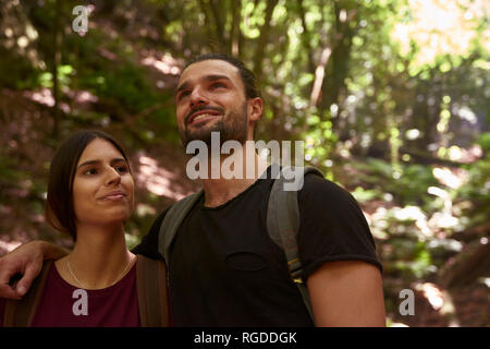 Spain, Canary Islands, La Palma, smiling couple in a forest looking around Stock Photo