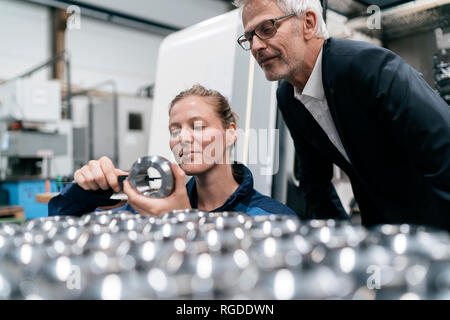 Manager and skilled worker in high tech enterprise, checking machine parts Stock Photo