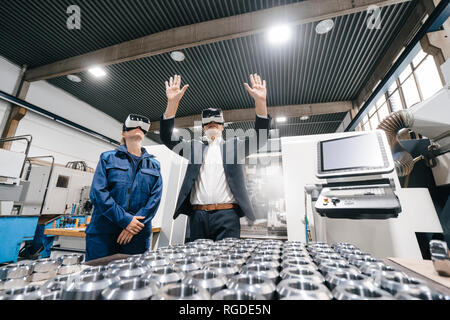 Businessman and skilled worker in high tech enterprise, using VR glasses Stock Photo