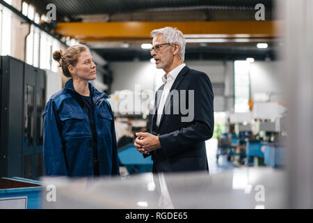 Manager and skilled worker of a high tech enterprise having a meeting Stock Photo