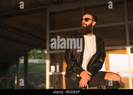 Stylish bearded young man outdoors looking sideways Stock Photo