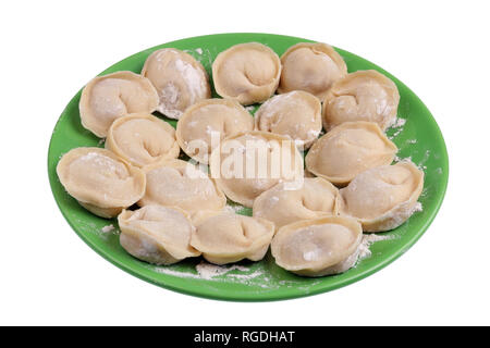 Homemade raw dumplings with pork meat on a green plate. Isolated on white studio closeup Stock Photo