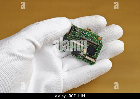 A technician controls the quality of a modern printed circuit board for digital camera. Pbf -  lead metall free.  Modern technology  macro concept. Stock Photo