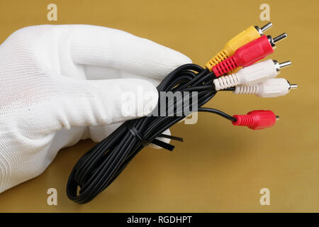 A technician controls the quality of a new  audio video cables  for home blue ray player. Mass production. Modern technology  macro concept. Stock Photo