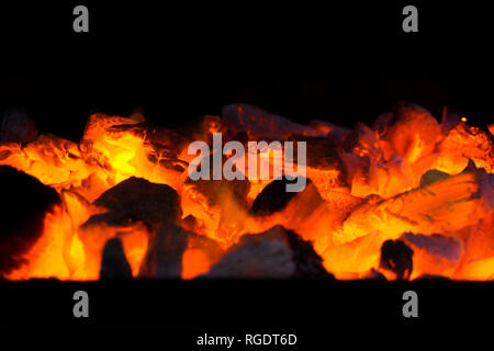 Glowing embers in hot red color. Embers closeup. Embers after a fire. Stock Photo