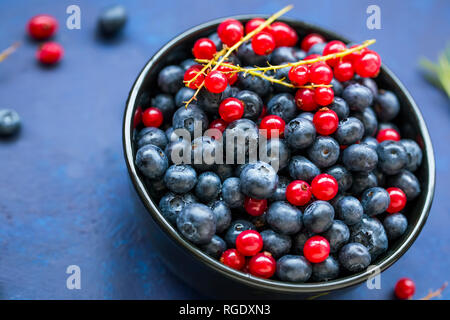 Bowl of healthy organic berries with blueberries and red currants, fresh sweet organic berries top view