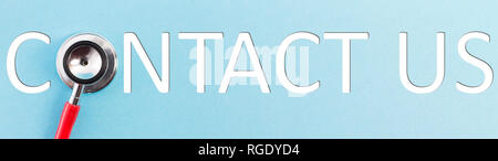 Contact us text with stethoscope as letter on blue background as call concept Stock Photo