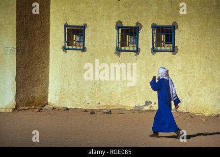 BORDJ EL HAOUAS, ALGERIA - JANUARY 16, 2002: Unknown man from the Touareg tribe crosses the main road in the middle of the desert Stock Photo