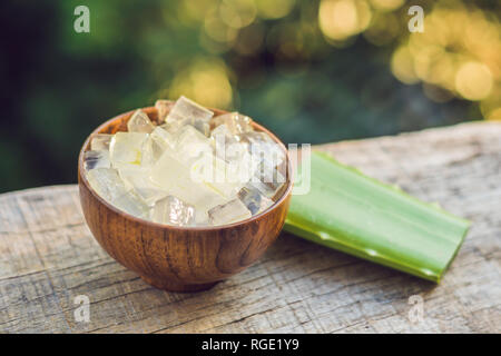 Aloe vera and aloe cubes in a wooden bowl. Aloe Vera gel almost use in food, medicine and beauty industry Stock Photo