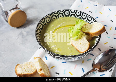 Healthy detox broccoli green cream soup in a bowl on concrete table. Stock Photo