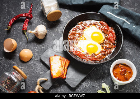 Shakshuka, Fried Eggs in Tomato Sauce in iron frying pan. Typical Israel food. Stock Photo