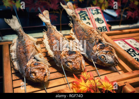 Grilled fishes on sticks as street food at Nishiki market, Kyoto, Japan Stock Photo