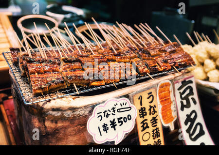 Grilled unagi or fresh water eel on sticks as street food at Nishiki market, Kyoto, Japan Stock Photo