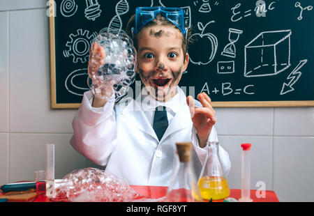 Funny happy boy dressed as chemist with dirty face after doing an experiment Stock Photo