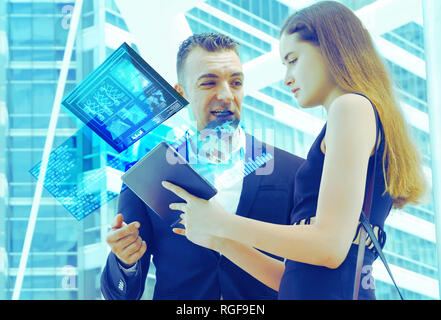 Man and woman watch futristic halogram data from A.I. device. Stock Photo