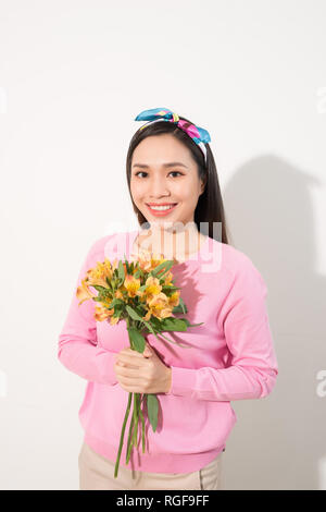 Toothy smiling happy woman holding flower . White background isolated portrait. Stock Photo