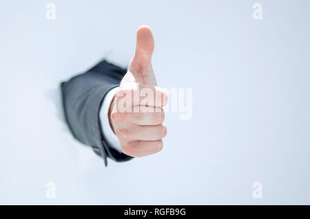 businessman breaks through the paper and shows his thumb up Stock Photo