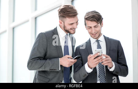 smiling employees with smartphones standing in the office. Stock Photo
