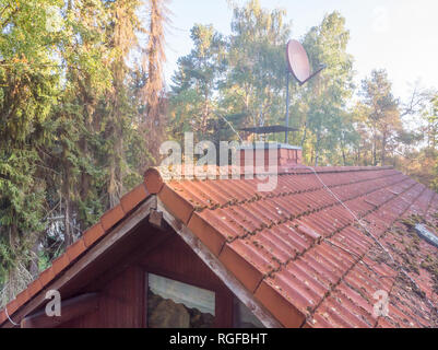 Inspection of the red tiled roof of a single-family house, inspection of the condition of the tiles on one roof side Stock Photo