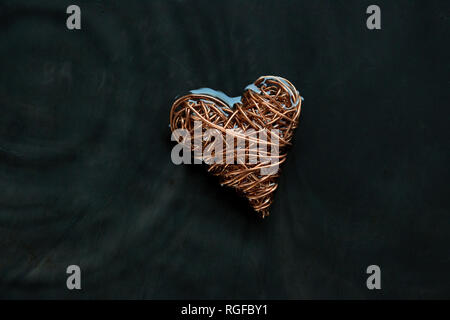 Copper wire heart made from reclaimed electric cable. Surrounding water disturbed to give concentic ripples.