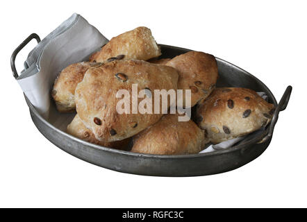 Just baked sourdough homemade buns with seeds lying in old antique metal basket with napkin - rustic quality. Isolated on white. Stock Photo