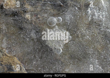 macro of an icy puddle or ice patterns on a gravel driveway in winter in Italy Stock Photo