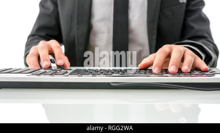 Cropped view of worker in suit sitting at his desk using computer. Stock Photo