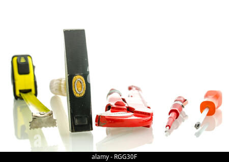 Various work tools on white desk with reflection. Isolated over white background. Stock Photo