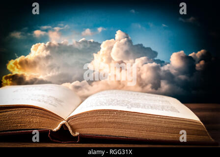 detailed book against the night sky with white and dark clouds Stock Photo