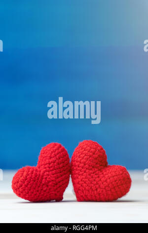 Valentines day concept. hand make two yarn red heart on wooden table and blue background Stock Photo