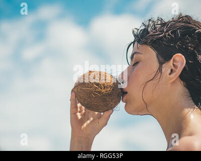 coconut oil production. coco milk. Clean eating diet, vegetarian and vegan. Woman is moisturizing her skin with a coconut cream. drinking beach