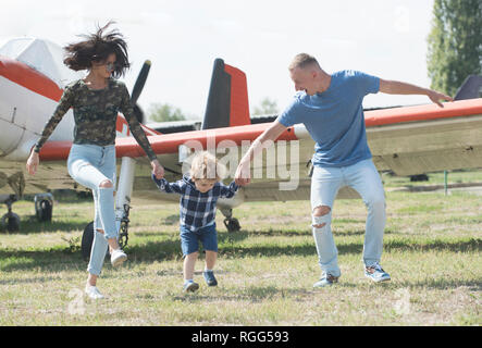 Lets start our journey. Travelling by air. Family on vacation trip. Couple with boy child at plane. Aircraft tour and travel. Air travel. Enjoying Stock Photo