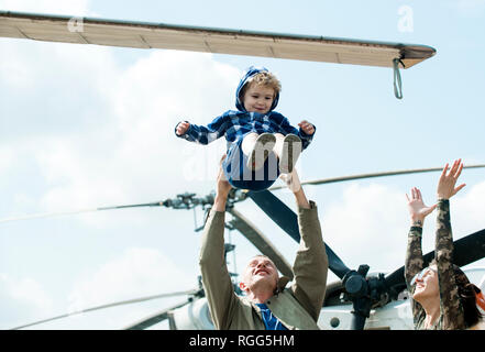 Enjoying travelling fun. Family vacation. Family couple with kid on vacation trip. Mother and father with son at helicopter. Helicopter tour and Stock Photo