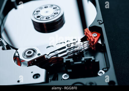 Closeup inside the assembly of hard disk drive actuator arm with read/write head and multi-layer magnetic platters discs. Stock Photo