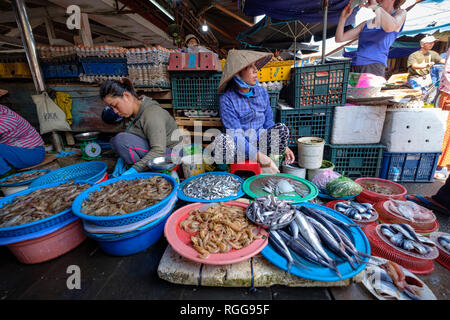 Woman wearing traditional vietnamese non la conical selling fish in a market in Hoi An, Vietnam, Southeast Asia Stock Photo