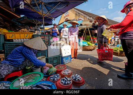 Woman wearing traditional vietnamese non la conical selling fish on the streets of Hoi An, Vietnam, Southeast Asia Stock Photo
