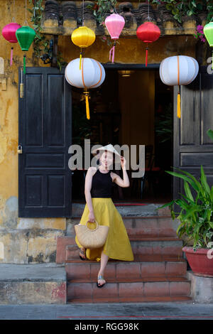 Portrait of young woman wearing a traditional vietnamese non la conical hat in old town Hoi An, Vietnam Stock Photo